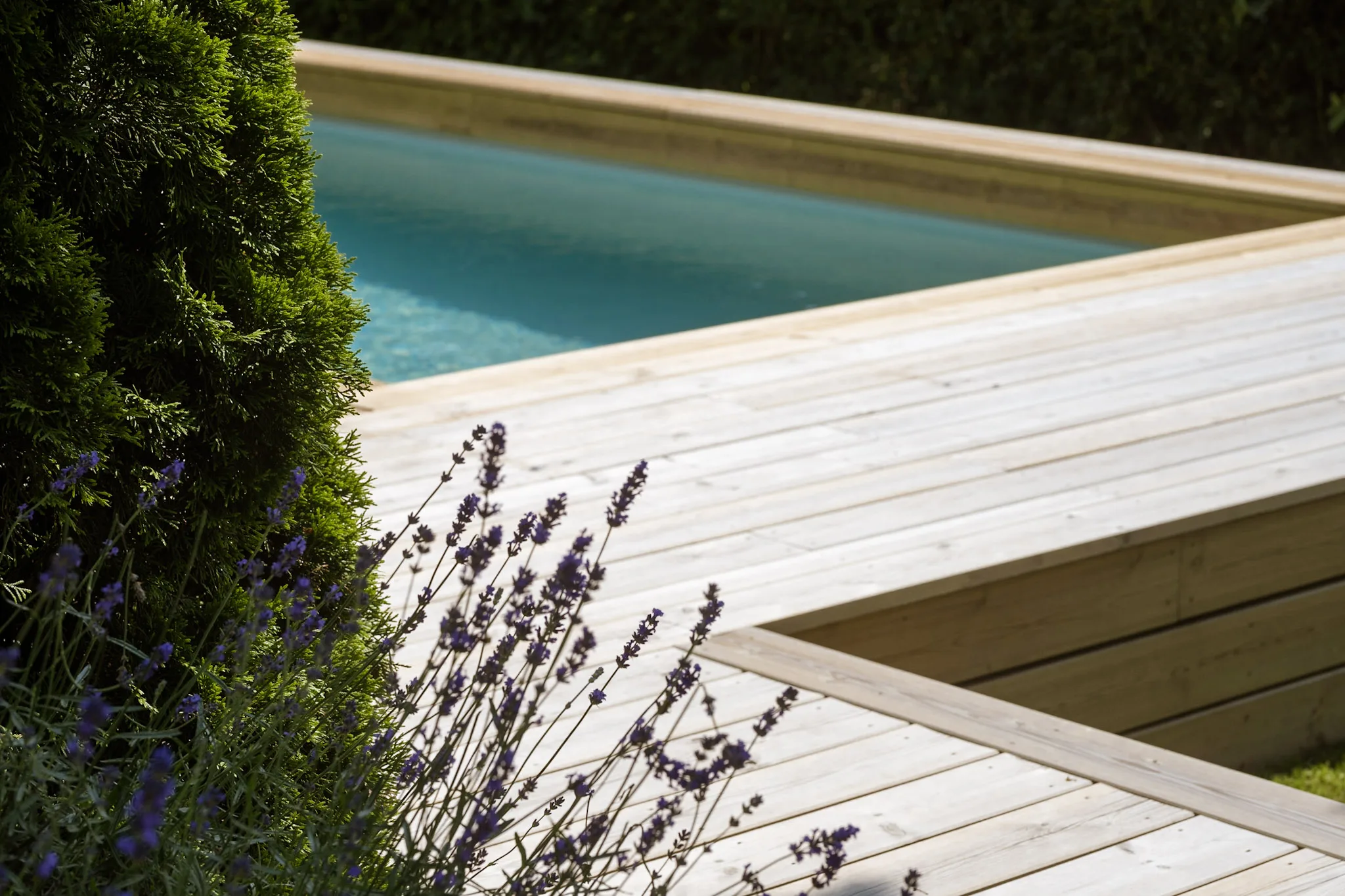 une terrasse en bois autour d’une piscine